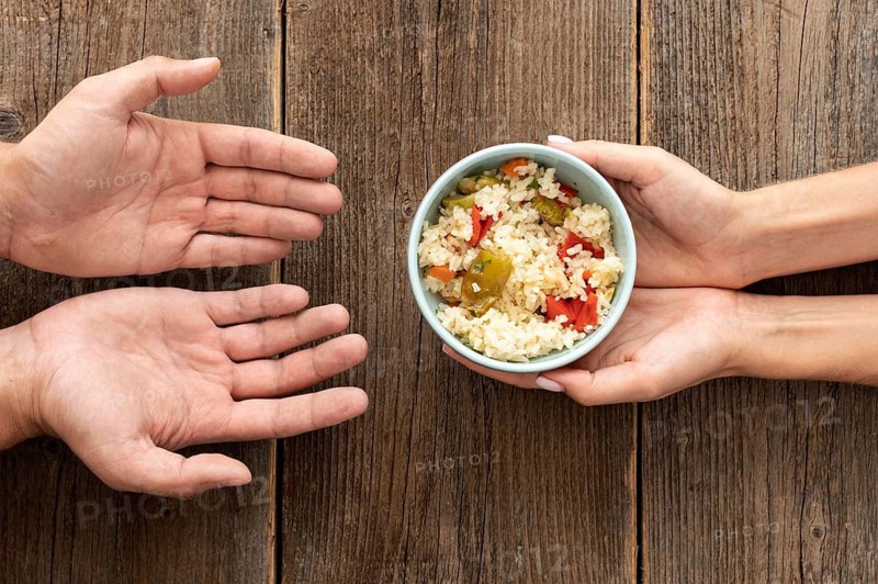 Hand giving bowl food needy person