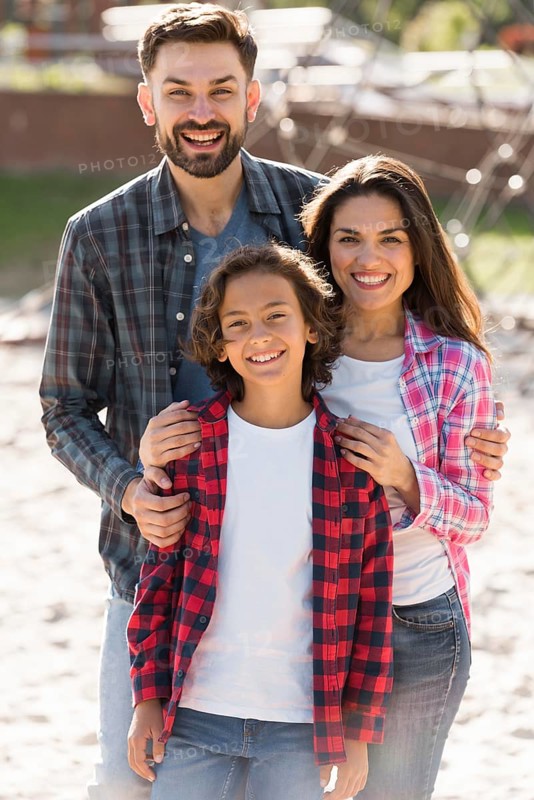 Front view parents with child posing while outdoors