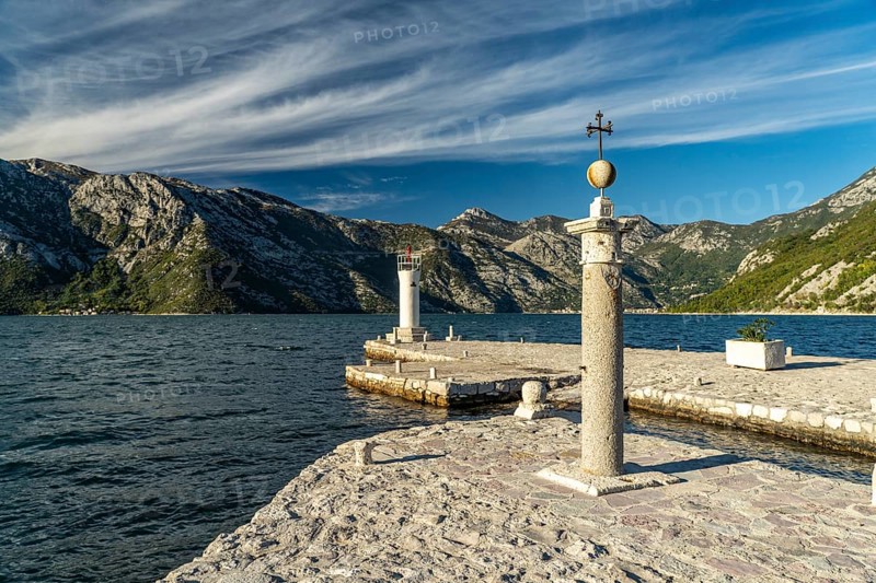 Cross and lighthouse on the artificial island of Gospa od Skrpjela near Perast on the Bay of Kotor