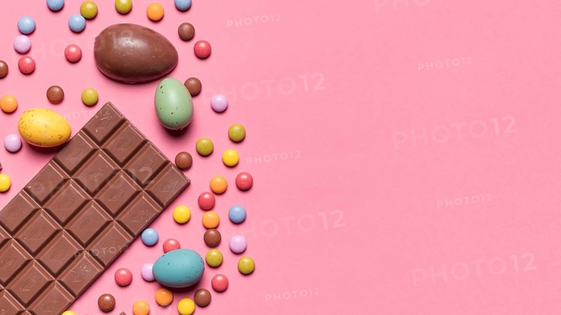 Chocolate bar easter eggs gem candies pink background