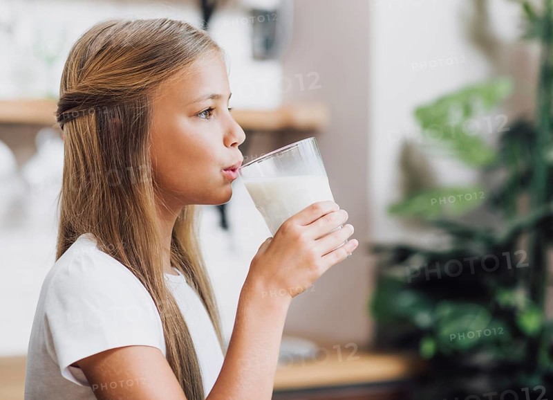 Side view girl drinking glass milk