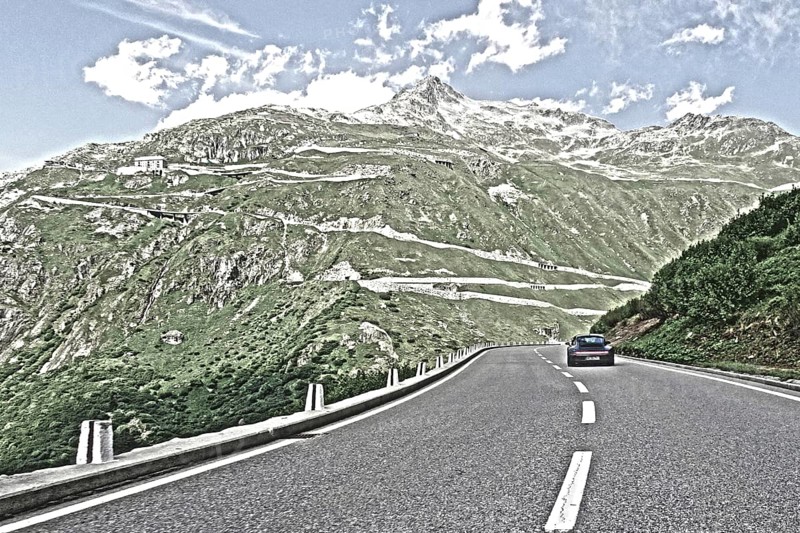 Photo with reduced dynamics saturation HDR of mountain pass alpine mountain road alpine road pass road pass view from Furka road to Furka pass in the background serpentines above tree line