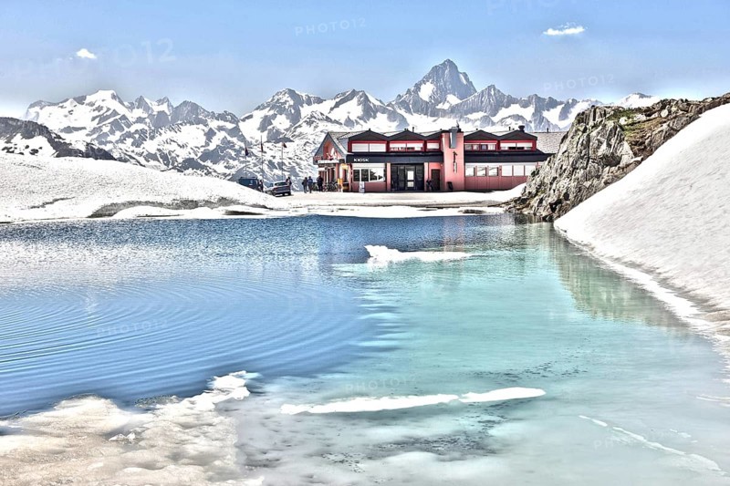 Photo with reduced dynamic range saturation HDR of mountain pass alpine mountain road alpine road pass road pass with snow and ice on mountain lake at pass height of Nufenen pass