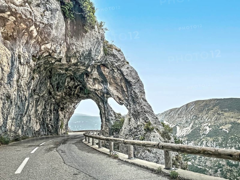 Photo with reduced dynamic range saturation HDR of view of rock arch rock formation with passage on road Route de Gentelly