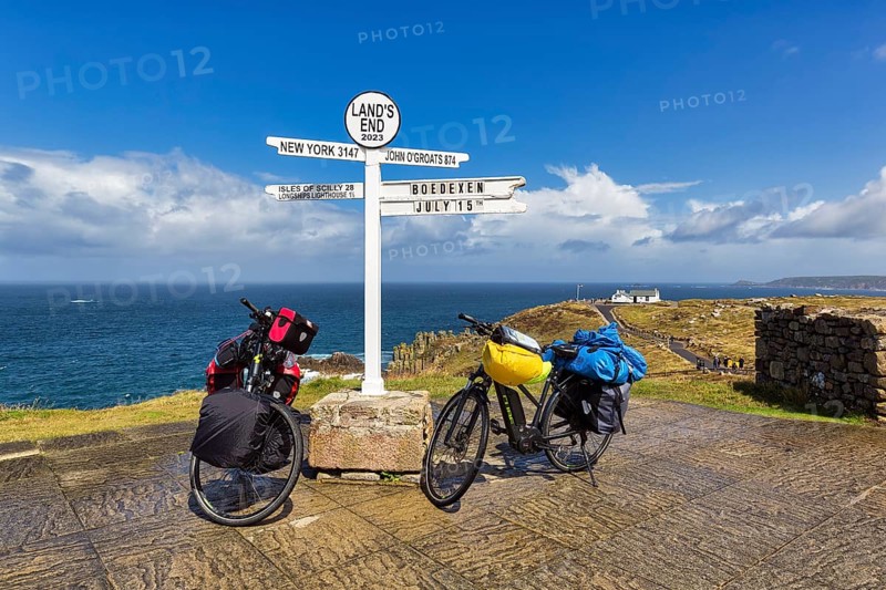 Two e-bikes at the famous signpost to New York