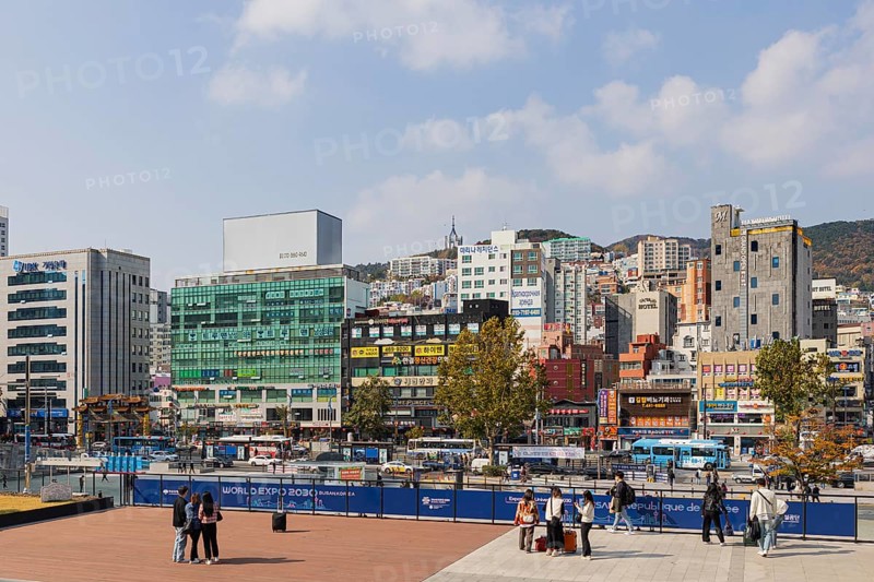 Station forecourt with high-rise buildings and shops