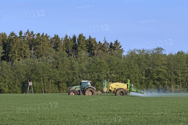 Farmer in tractor spraying herbicides