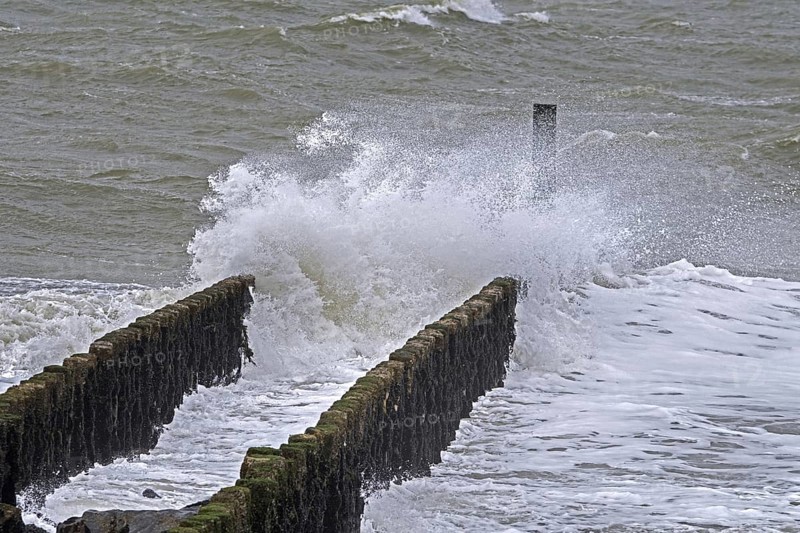 Wave crashing into wooden groyne