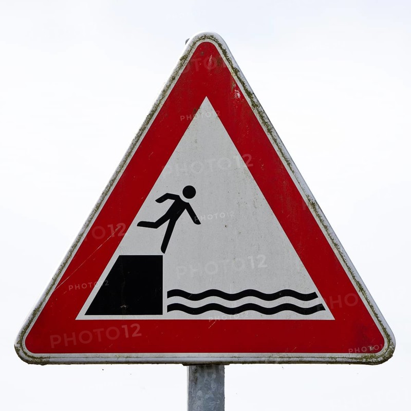Sign warns people not to fall off the edge into the water