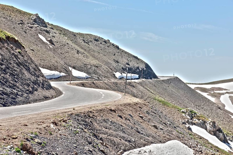 Photo with reduced dynamic saturation HDR of mountain pass alpine mountain road alpine road pass road pass view of highest asphalted alpine road ring road around Cime de la Bonette next to Col de la Bonette in high mountains above tree line