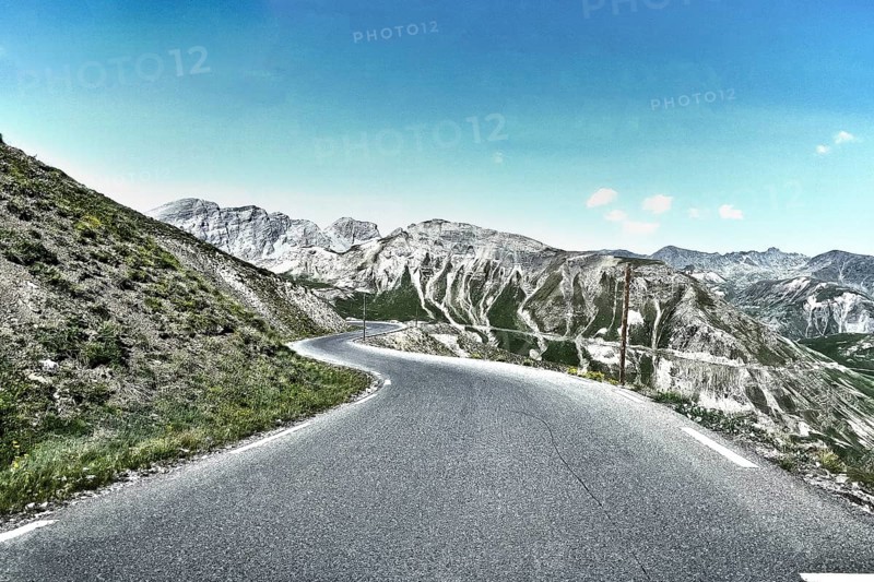 Photo with reduced dynamic range saturation HDR of mountain pass alpine mountain road alpine road pass road pass Col de Raspaillon in French Alps High Alps in high mountains above tree line