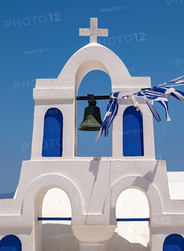 White bell tower with Greek flags