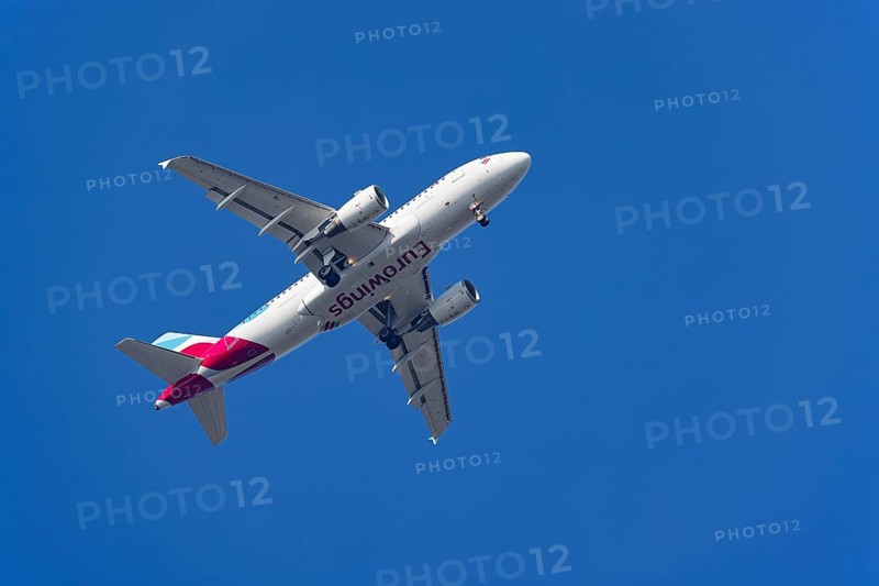 Passenger aircraft of the airline Eurowings in flight with extended landing gear