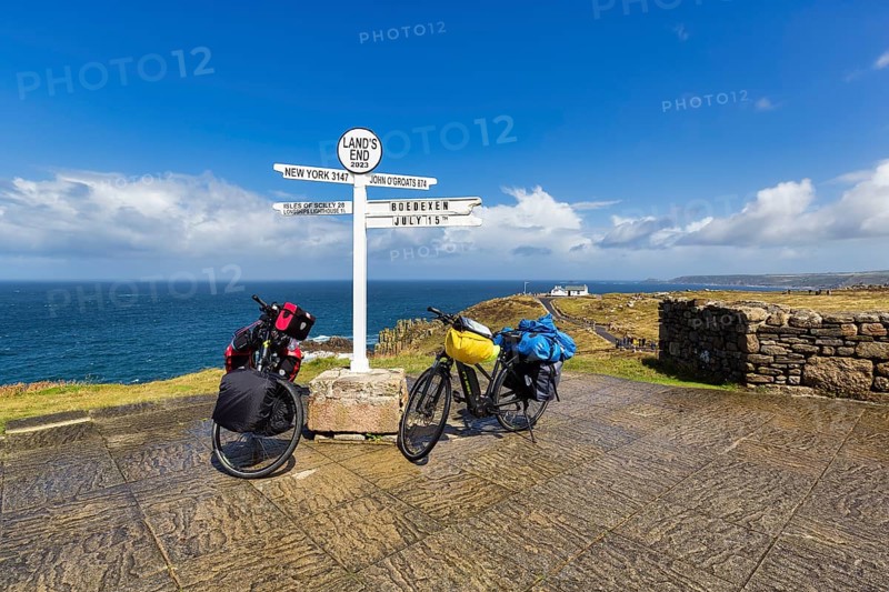 Two e-bikes at the famous signpost to New York