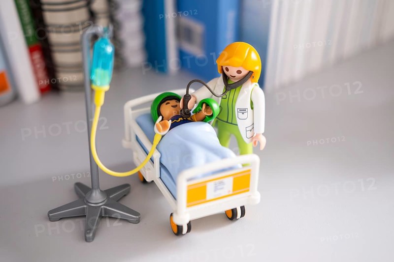 A Playmobil doctor examines a patient with a stethoscope