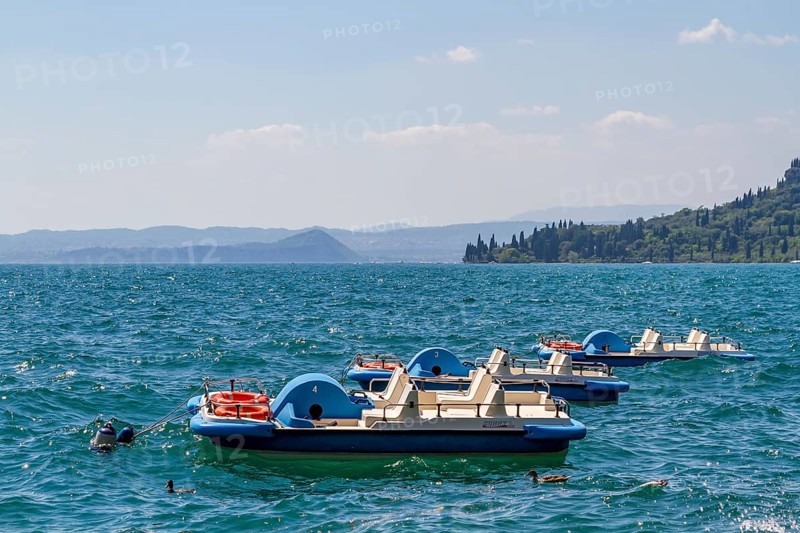 Three pedal boats anchored on Lake Garda