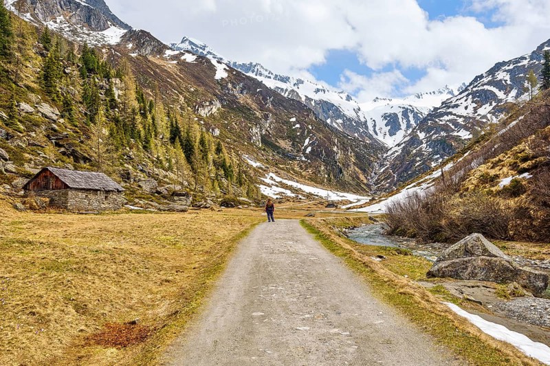Hiker next to alpine hut in Ahrntal