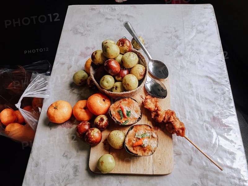 Haw mok or thai steamed red curry custard with clementine oranges and jujube fruit on a table