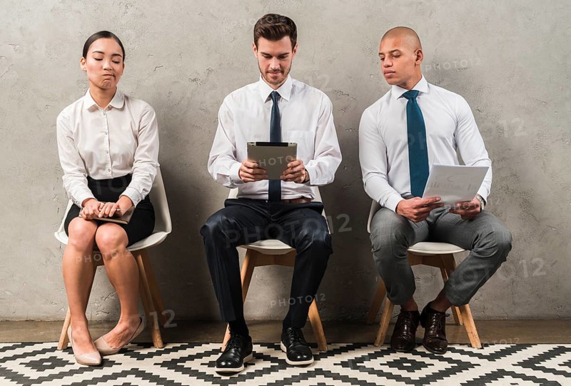 Jealous businesswoman sitting near businessman using digital tablet