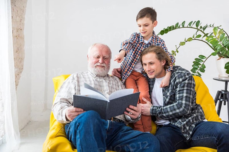 Multigenerational men watching album