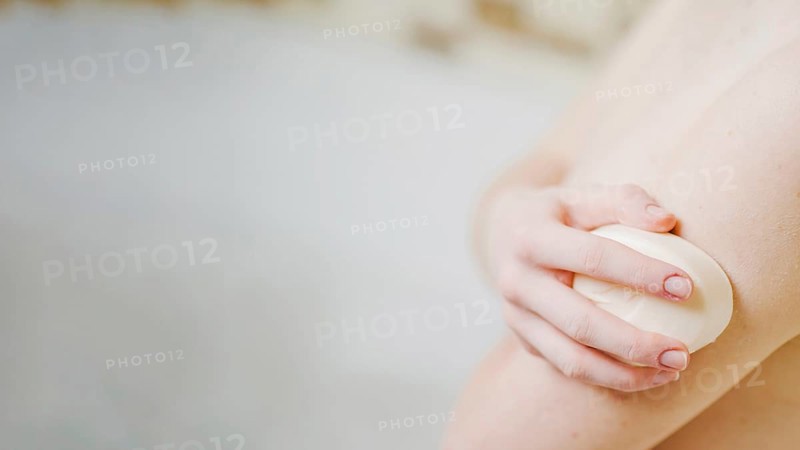Anonymous girl washing with soap