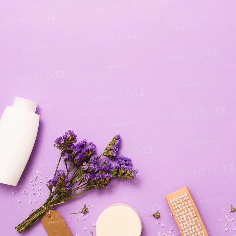Flat lay frame with white bottle lilac flower
