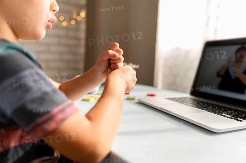 Boy talking with his teacher online school