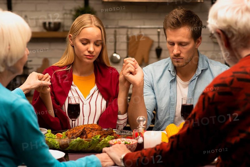 Family praying dinner table