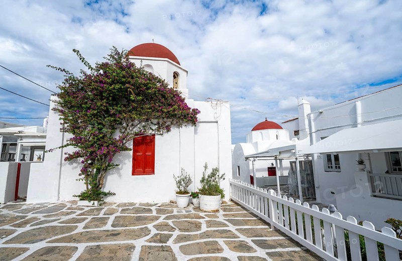 White Greek Orthodox Church of St Nicholas with red roof and bougainvillea