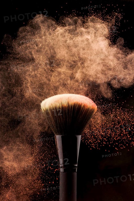 Makeup brush with peach color powder splash