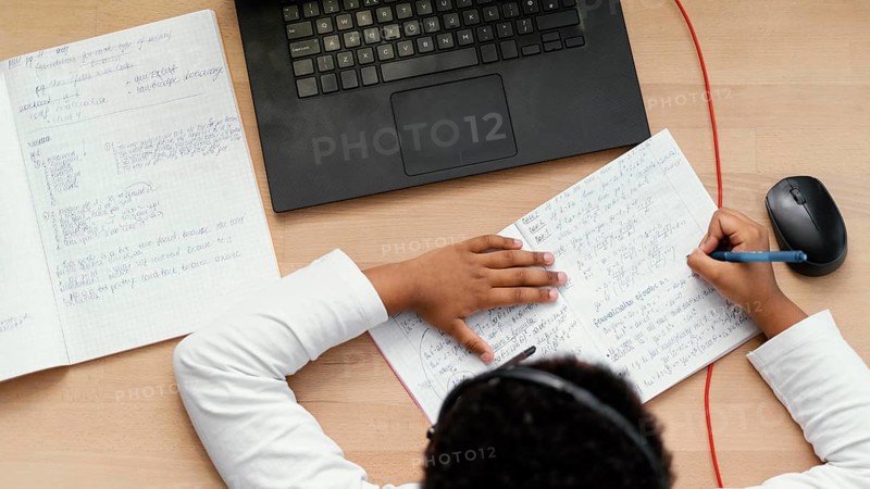Boy doing homework with use laptop