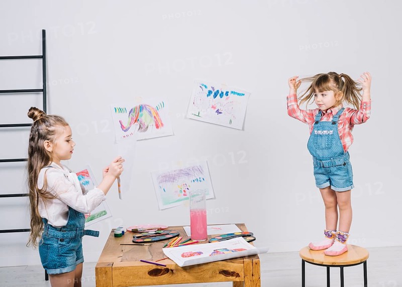 Little girl painting posing girl chair