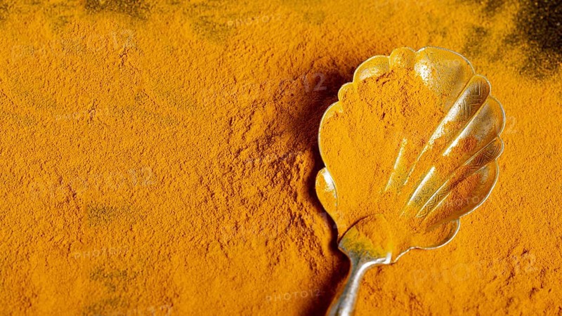 Top view spoon with turmeric with copy space