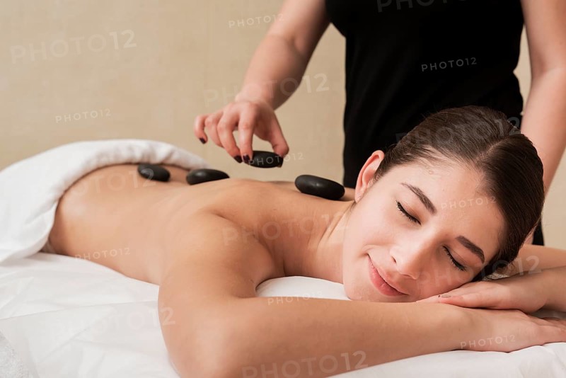 Woman enjoying hot rocks therapy spa