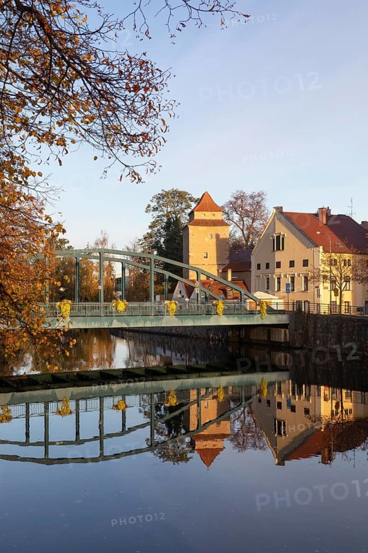 Autumnal coloured trees with iron bridge over the river Maltsch with the city wall of the historical old town of Ceske Budejovice