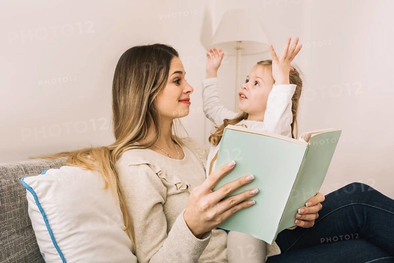 Girl telling story mom while reading book