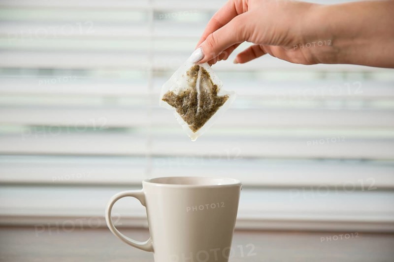Hand holding tea bag