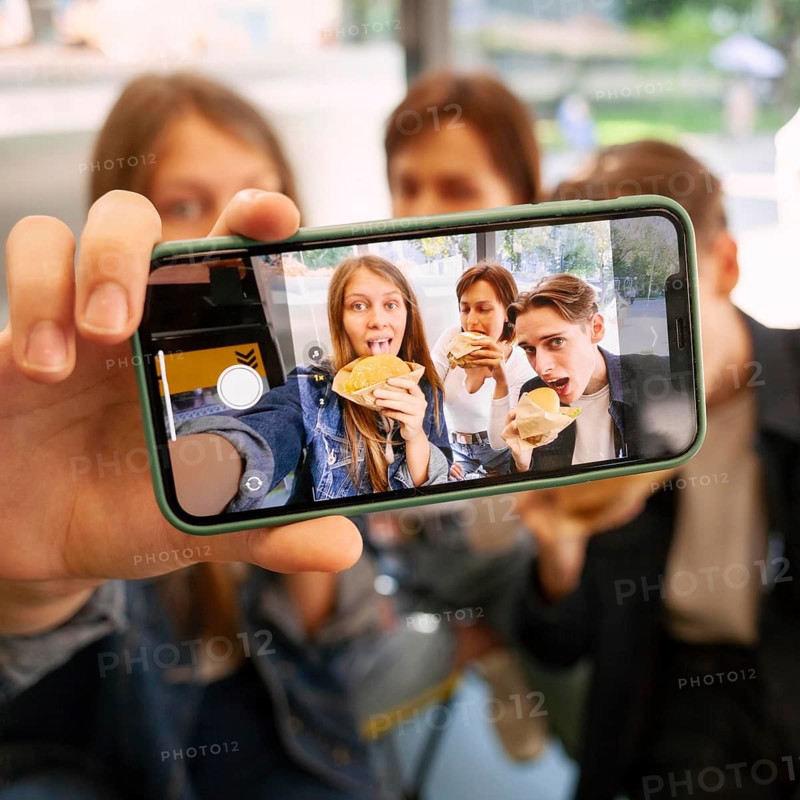 Group friends taking selfie together while eating fast food