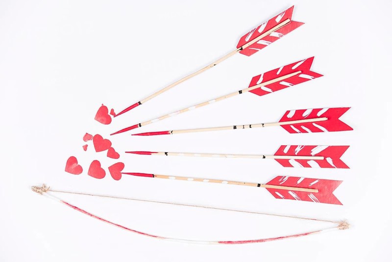 Love arrows aiming small red hearts