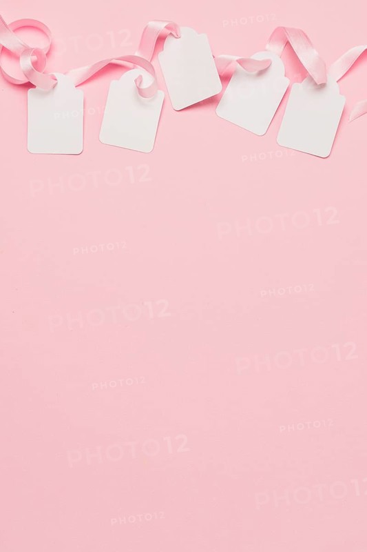 White tags pink ribbon top background with space text