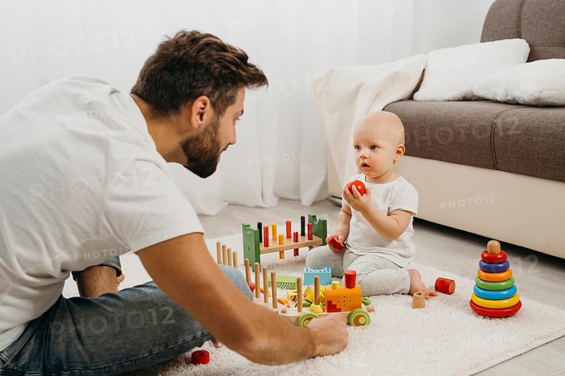 Father teaching baby play with toys