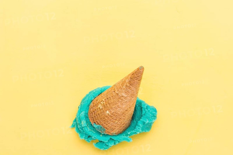 Blue ice cream cone falling yellow background