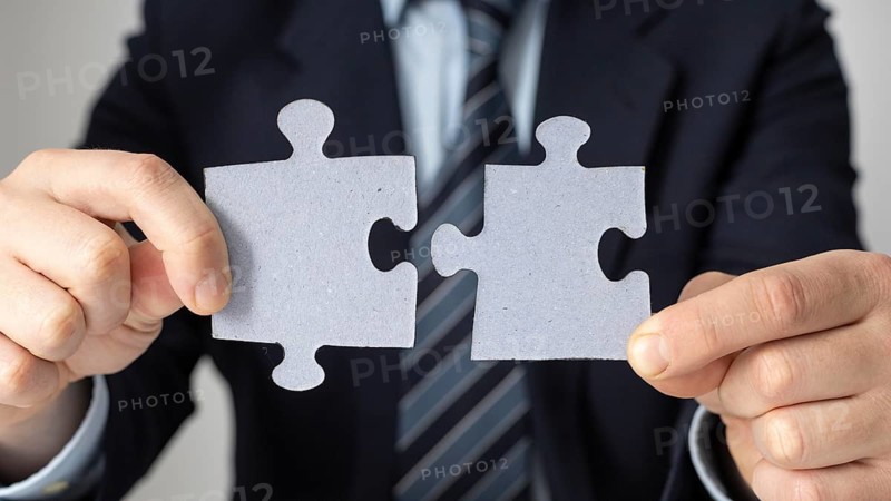 Businessman holding two puzzle pieces