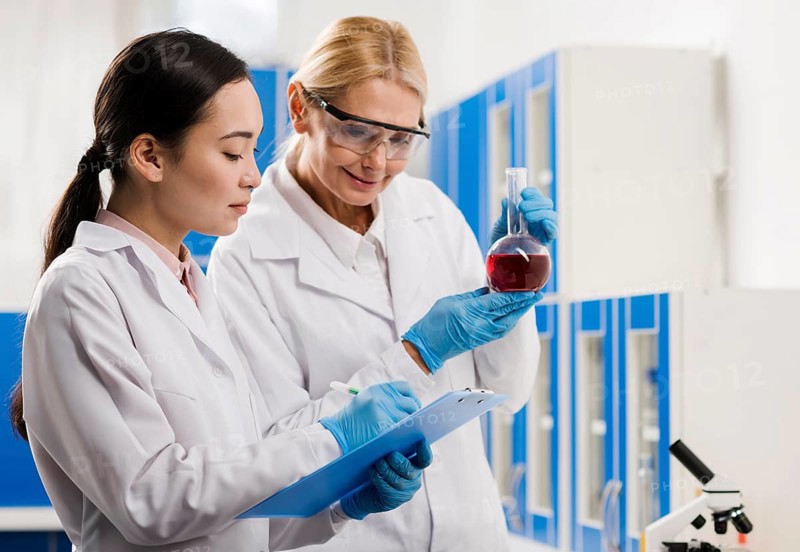 Side view female scientists analyzing substance lab