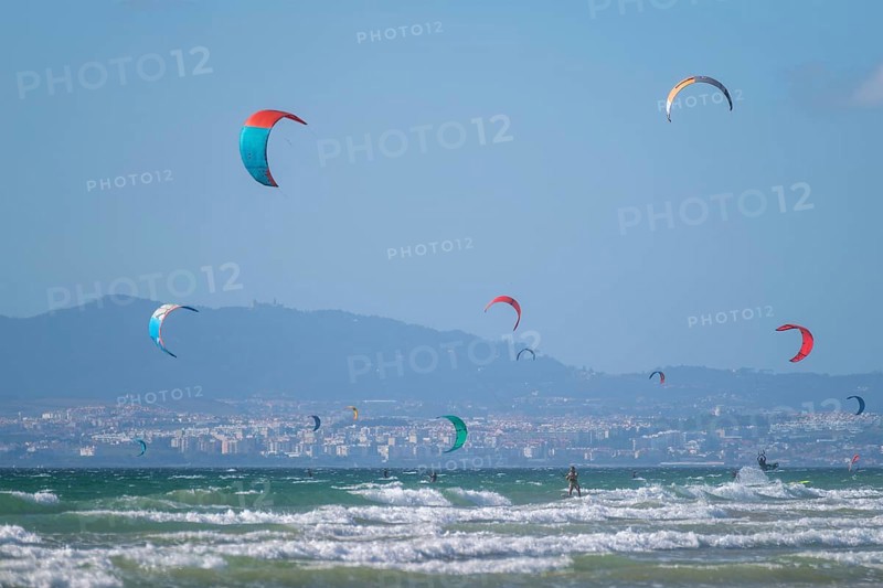 Kiteboarding kitesurfing kiteboarder kitesurfer kites on the Atlantic ocean beach at Fonte da Telha beach