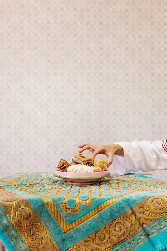 Hand taking piece arab pastry