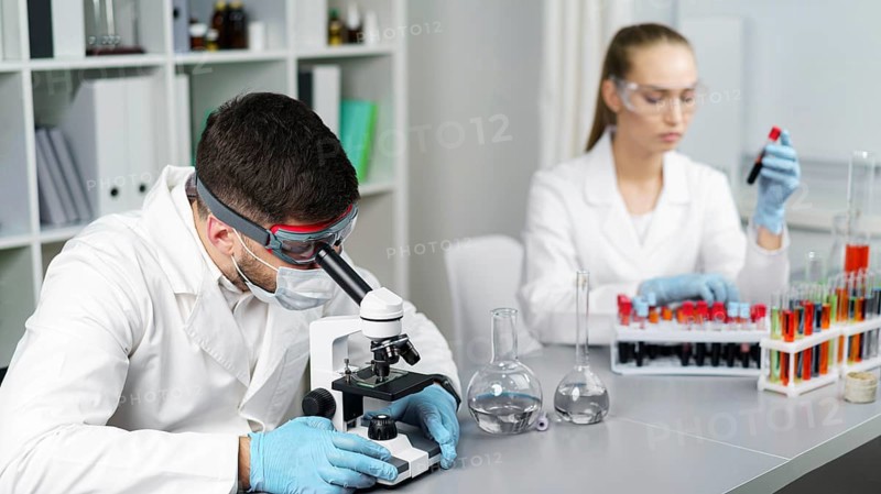 Female researcher male colleague laboratory with test tubes safety glasses
