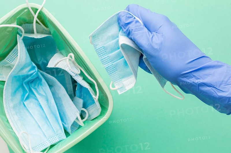 Person wearing protection gloves taking disposable mask