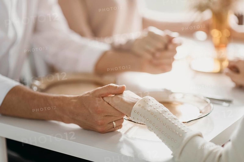Beautiful family praying before eating close up