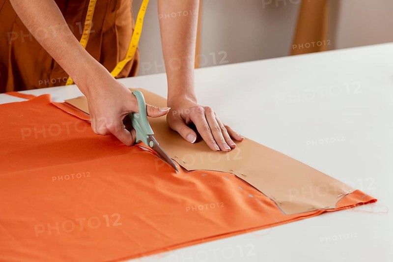 Close up hands cutting fabric